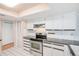 Galley kitchen featuring granite countertops, stainless steel range, and white cabinets at 2063 De Carlo Ave, Spring Hill, FL 34608