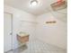 Functional laundry room features a utility sink, tiled floors, and storage shelves for added convenience at 2063 De Carlo Ave, Spring Hill, FL 34608