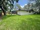 Spacious backyard featuring lush green grass and a screened-in pool area at 2102 Doefield Ct, Valrico, FL 33596