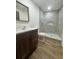Bathroom featuring updated vanity, marble tile shower with niche, and hardwood flooring at 2102 Doefield Ct, Valrico, FL 33596
