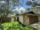 Attached garage featuring a wooden door and stone accent wall, adjacent to a lawn at 2102 Doefield Ct, Valrico, FL 33596