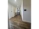Hallway with wood-look flooring leading to a bathroom and a cabinet with decorative rattan panels at 2102 Doefield Ct, Valrico, FL 33596