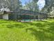 Beautiful backyard view showcasing a screened pool area surrounded by well-maintained landscaping at 2102 Doefield Ct, Valrico, FL 33596