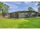 Exterior view of a large screened-in patio and backyard with lush green grass at 21906 Shamu Dr, Land O Lakes, FL 34639