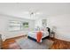 Well-lit bedroom with hardwood floors, a large window, and a comfortable bed with flamingo artwork at 21906 Shamu Dr, Land O Lakes, FL 34639