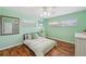 Mint bedroom with two windows, ceiling fan, and wood-look flooring at 21906 Shamu Dr, Land O Lakes, FL 34639