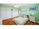 Green bedroom with hardwood floors, bright lighting, and closet space at 21906 Shamu Dr, Land O Lakes, FL 34639