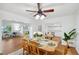 Bright dining room features wood floors and a ceiling fan with light fixture at 21906 Shamu Dr, Land O Lakes, FL 34639