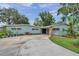 Inviting exterior of a blue home featuring a circular driveway and charming stone accents at 21906 Shamu Dr, Land O Lakes, FL 34639