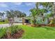 Charming single-story home with a lush front lawn and mature tropical landscaping at 21906 Shamu Dr, Land O Lakes, FL 34639
