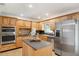 Well-lit kitchen featuring an island, stainless steel appliances and wood cabinets at 21906 Shamu Dr, Land O Lakes, FL 34639