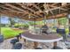 Entertainer's dream outdoor kitchen with stone bar, grill, fans, and seating area at 21906 Shamu Dr, Land O Lakes, FL 34639