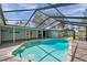 Inviting enclosed swimming pool with stone deck and backyard access, ideal for outdoor relaxation and lake views at 21906 Shamu Dr, Land O Lakes, FL 34639