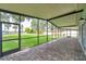 Spacious screened-in porch with brick flooring, offering beautiful views of the backyard and lake at 21906 Shamu Dr, Land O Lakes, FL 34639