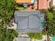Aerial shot showcasing a home with a dark roof, screened pool, and charming brick patio in a lush setting at 2604 W Jetton Ave, Tampa, FL 33629