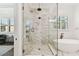 Sleek bathroom featuring glass shower, soaking tub, marble accents, and modern fixtures at 2604 W Jetton Ave, Tampa, FL 33629