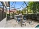 Outdoor kitchen area with built-in grill and lounge chairs in screened-in lanai at 2604 W Jetton Ave, Tampa, FL 33629