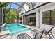 Lovely outdoor covered patio with pool, waterfall, patio seating and lush foliage at 2604 W Jetton Ave, Tampa, FL 33629
