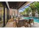 Outdoor covered patio with beautiful pool, patio seating, grill and tropical plants at 2604 W Jetton Ave, Tampa, FL 33629
