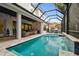 Lovely outdoor covered patio with pool, waterfall, patio seating and lush foliage at 2604 W Jetton Ave, Tampa, FL 33629