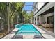 Beautiful screened-in pool area with a waterfall feature and comfortable seating at 2604 W Jetton Ave, Tampa, FL 33629