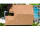 Aerial view of a home featuring a brown roof, patio, inground pool and lush green backyard at 28826 Windover St, Wesley Chapel, FL 33545
