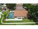 Aerial view of a home with a screened pool, fenced yard, and mature landscaping in a well-kept neighborhood at 28826 Windover St, Wesley Chapel, FL 33545