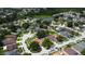 Aerial view of a planned residential community with mature trees, manicured lawns, and a pond in the background at 28826 Windover St, Wesley Chapel, FL 33545