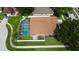 Aerial view of a home with a screened pool, fenced yard, and mature landscaping in a well-kept neighborhood at 28826 Windover St, Wesley Chapel, FL 33545