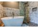 Modern bathroom features a sleek soaking tub and glass-enclosed shower with stylish tile at 28826 Windover St, Wesley Chapel, FL 33545