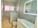 This bathroom features a marble tiled walk in shower with glass enclosure and a modern lighted mirror over the vanity at 28826 Windover St, Wesley Chapel, FL 33545