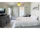 Bright bedroom with ceiling fan, dresser, and slider to the outside patio at 28826 Windover St, Wesley Chapel, FL 33545