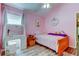 Charming pink bedroom with decor, window, vanity, and wood-look laminate flooring at 28826 Windover St, Wesley Chapel, FL 33545
