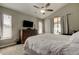 Bedroom with ceiling fan, dresser, and sliding glass doors to a lanai and backyard at 28826 Windover St, Wesley Chapel, FL 33545