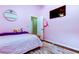 A pink bedroom with a wooden bed, a TV, and a cute pink backpack hanging on the door at 28826 Windover St, Wesley Chapel, FL 33545