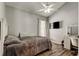 Comfortable bedroom with sleek TV on the wall, a makeup table, and a ceiling fan at 28826 Windover St, Wesley Chapel, FL 33545