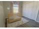 Cozy Bedroom with a wooden crib, a large window with curtains, and a spacious closet at 28826 Windover St, Wesley Chapel, FL 33545