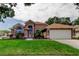 Charming single-story home featuring arched windows, lush landscaping, and an attached two-car garage at 28826 Windover St, Wesley Chapel, FL 33545