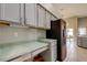 Kitchen with gray cabinets, stainless fridge, and a breakfast nook with views of the backyard at 28826 Windover St, Wesley Chapel, FL 33545