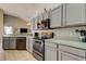Well-lit kitchen features gray cabinets, tile floors, stainless appliances, and decorative rooster figurines at 28826 Windover St, Wesley Chapel, FL 33545