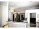 Open floor plan, breakfast bar and kitchen with stainless steel refrigerator and neutral decor at 28826 Windover St, Wesley Chapel, FL 33545