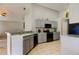 Bright kitchen with gray cabinets, stainless steel appliances, and a breakfast bar overlooking the living room at 28826 Windover St, Wesley Chapel, FL 33545