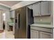 Kitchen features a stainless steel refrigerator and desk area with gray cabinets and tile floors at 28826 Windover St, Wesley Chapel, FL 33545