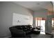 Spacious living room with a black leather sectional, views to the outdoor patio, and open floor plan at 28826 Windover St, Wesley Chapel, FL 33545