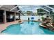 Beautiful pool with a rock waterfall feature inside a screened enclosure at 28826 Windover St, Wesley Chapel, FL 33545
