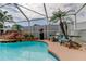 Inviting pool area featuring a rock waterfall, lush plants, and comfortable lounge chairs at 28826 Windover St, Wesley Chapel, FL 33545