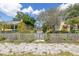 View of a vacant lot with a weathered fence, surrounded by charming homes at 2910 11Th N St, St Petersburg, FL 33704