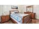 Cozy bedroom with wooden furniture, patterned duvet, and seaside artwork at 3315 58Th S Ave # 311, St Petersburg, FL 33712