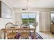 Bright dining room features a modern light fixture, a table set for four, and a view of the community pool at 3315 58Th S Ave # 311, St Petersburg, FL 33712