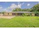 Expansive backyard with a brick patio, screen porch, and a home with a metal roof at 3505 Medulla Rd, Plant City, FL 33566
